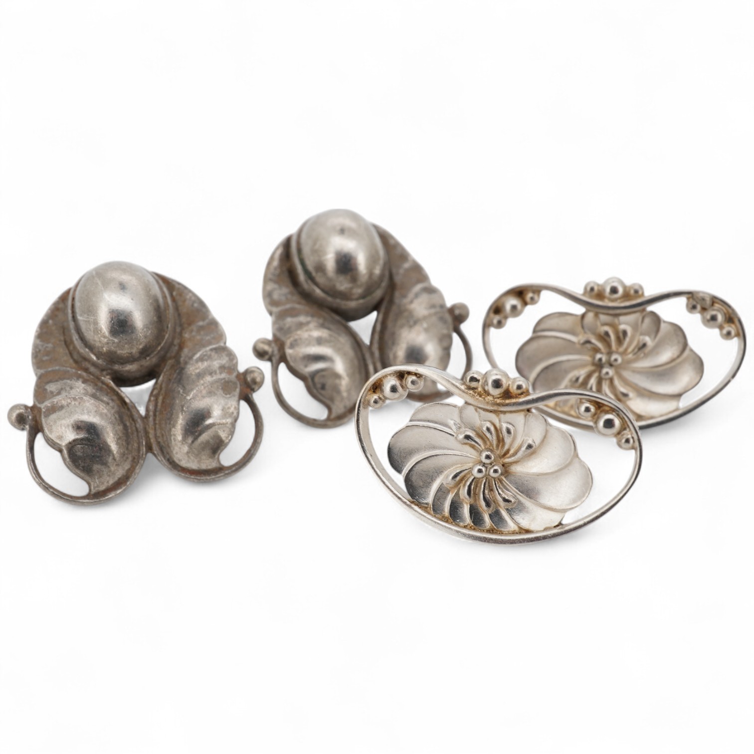 Two pairs of Georg Jensen sterling ear studs, one pair of leaf and berry design, 18mm and flower head form, design no. 52, lacking butterflies.